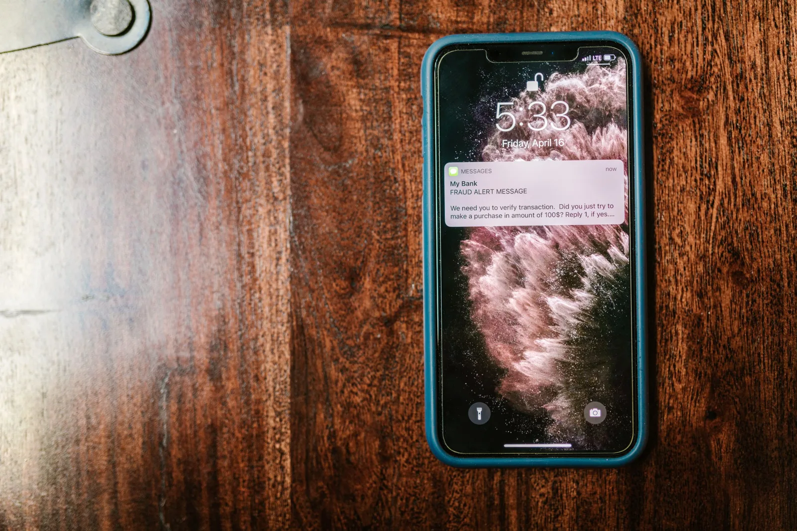 Un smartphone affiche un SMS inconnu « Bonjour, vous êtes chez vous ? » et un colis flouté.